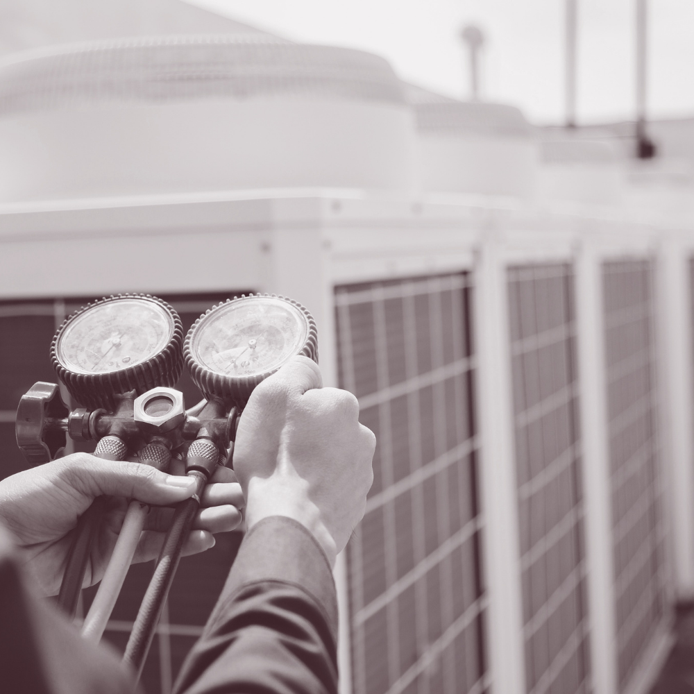 A technician providing services to air conditioners using a device.