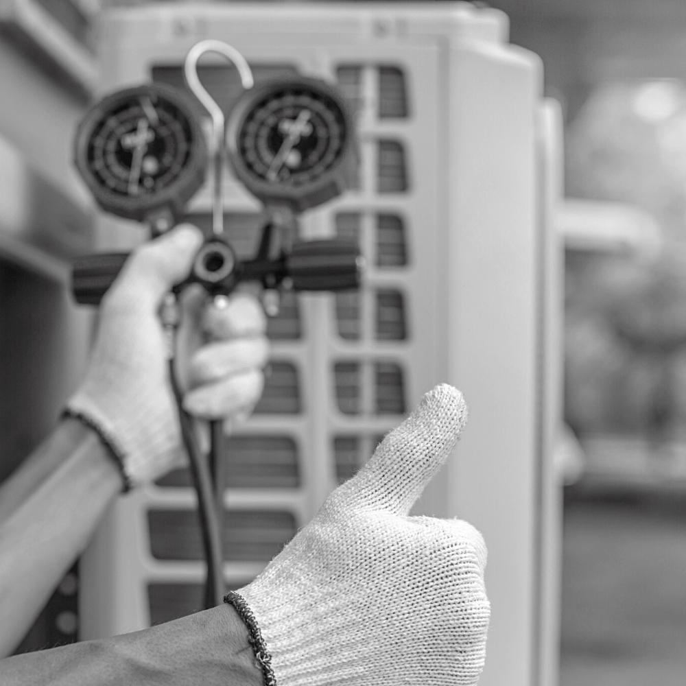 A person performing Air Conditioner Maintenance holding a pair of scissors with gloves on.