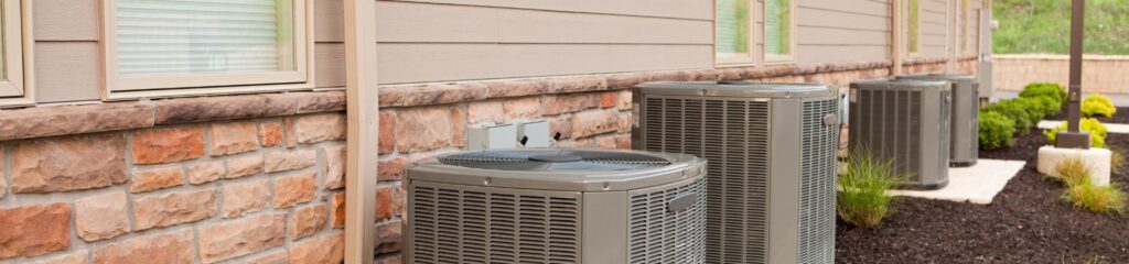 Commonly Asked Questions 5 a couple of air conditioners sitting on the side of a building.