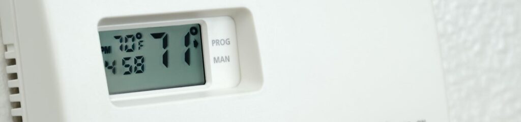 Commonly Asked Questions 7 a close up of a thermostaer on a wall.