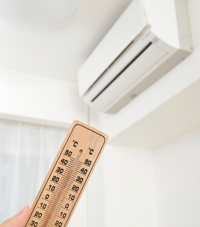 a person checking AC temperature with a thermometer.
